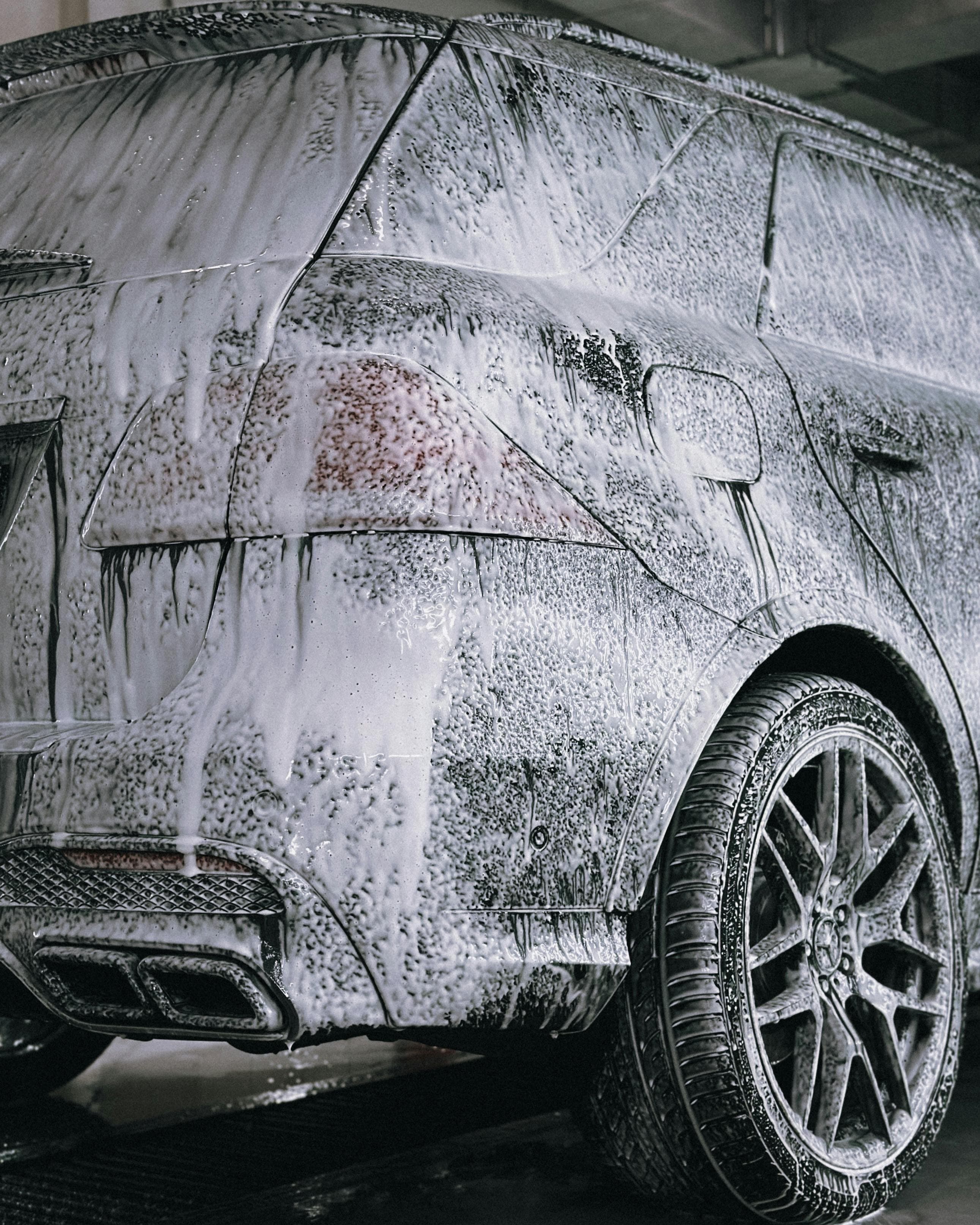 Car covered in soap being professionally detailed